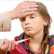 Sick school girl with nurse checking temperature