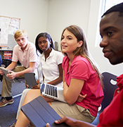 Group of teenage students talking in classroom