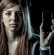Girl holding phone cyber bullying