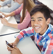 Middle school boy with cell phone in class