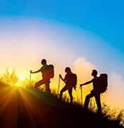 3 Backpackers hiking into the sunset