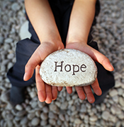 Child holding "hope" rock 