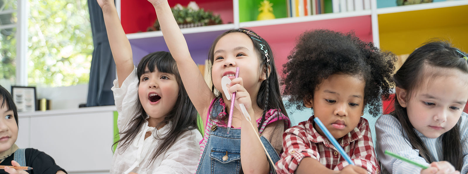 Group of little preschool kids drawing paper with color pencils . portrait of children friends