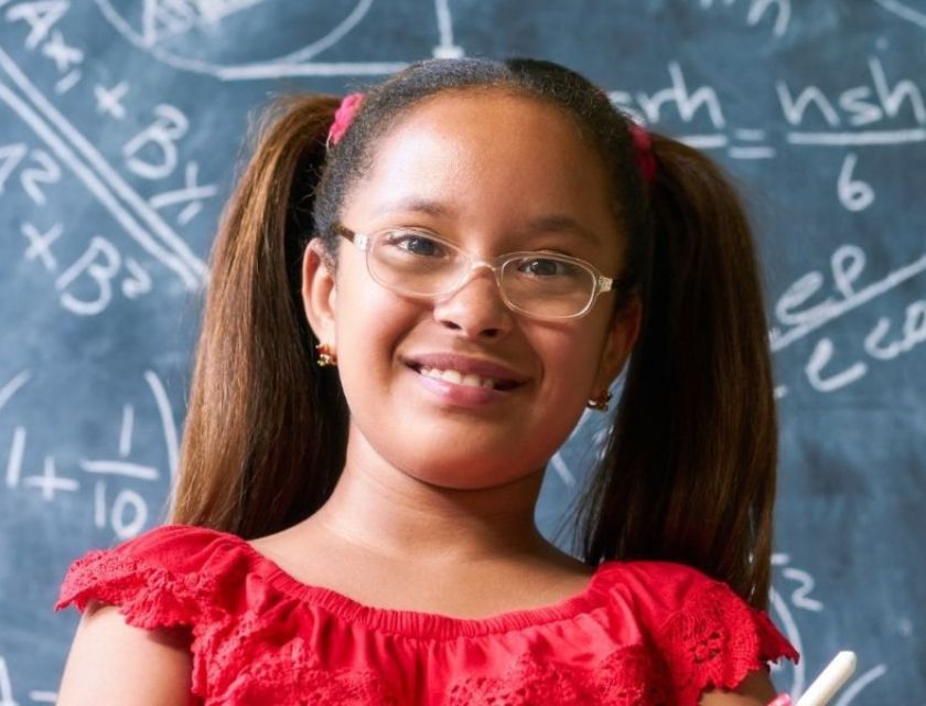 Girl in front of black board doing math