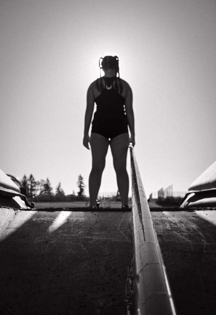 A black-and-white photo of a pole vaulter preparing to jump.