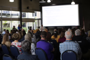 High School and Beyond group convening at a conference in a room with about 50 people looking at a screen